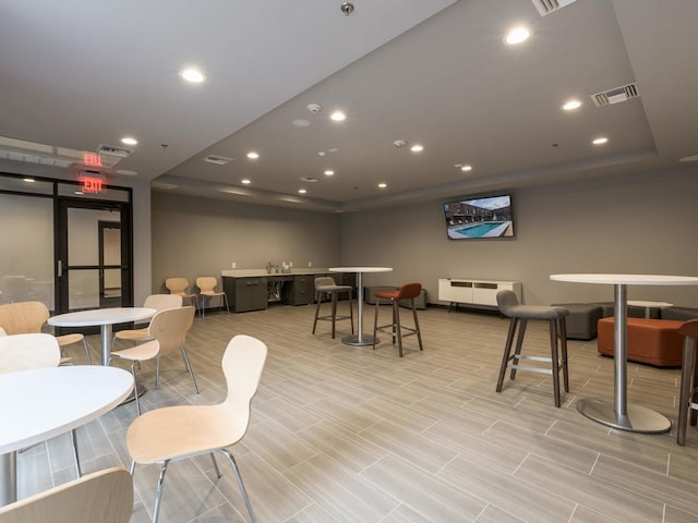 rec room featuring a tray ceiling and radiator heating unit