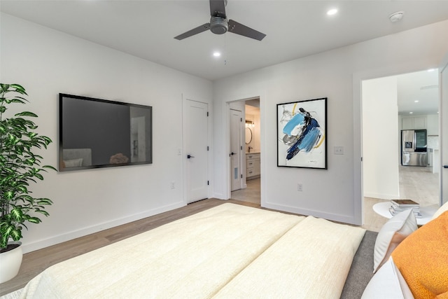 bedroom featuring ensuite bath, stainless steel fridge with ice dispenser, hardwood / wood-style floors, and ceiling fan