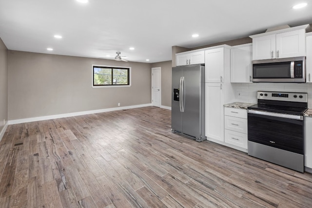 kitchen featuring stainless steel appliances, ceiling fan, decorative backsplash, and light hardwood / wood-style flooring