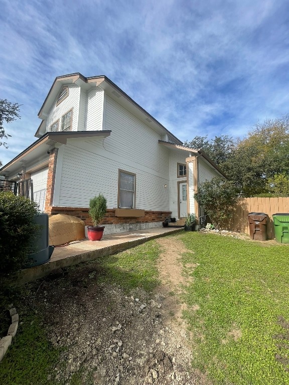 view of side of home featuring a garage and a lawn