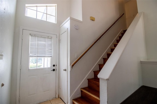 doorway featuring stairway and light tile patterned flooring