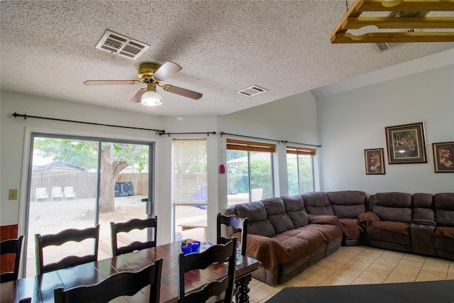 living area featuring light tile patterned floors, visible vents, and a textured ceiling