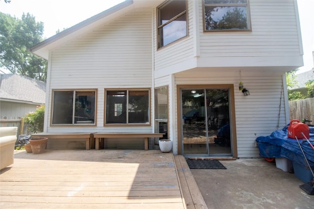 rear view of property featuring a deck and fence