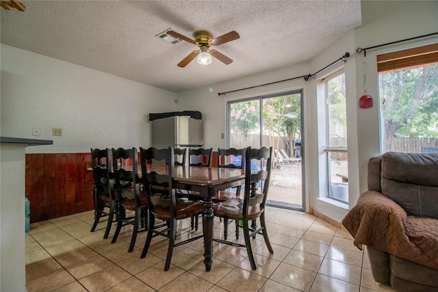 dining area featuring ceiling fan, light tile patterned floors, visible vents, and a textured ceiling