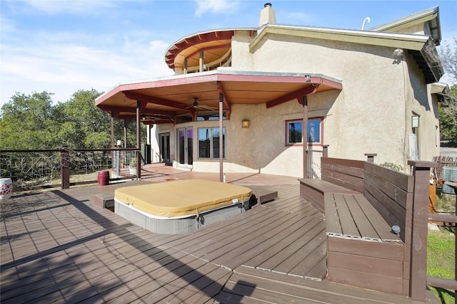 wooden deck with ceiling fan and a covered hot tub