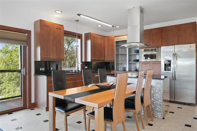 kitchen with light tile patterned floors, decorative light fixtures, stainless steel appliances, and island exhaust hood