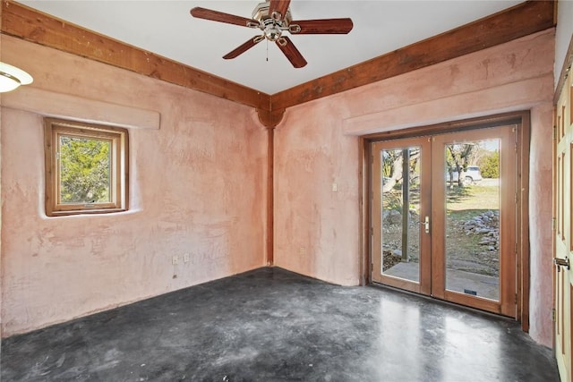 empty room with a wealth of natural light, french doors, and ceiling fan