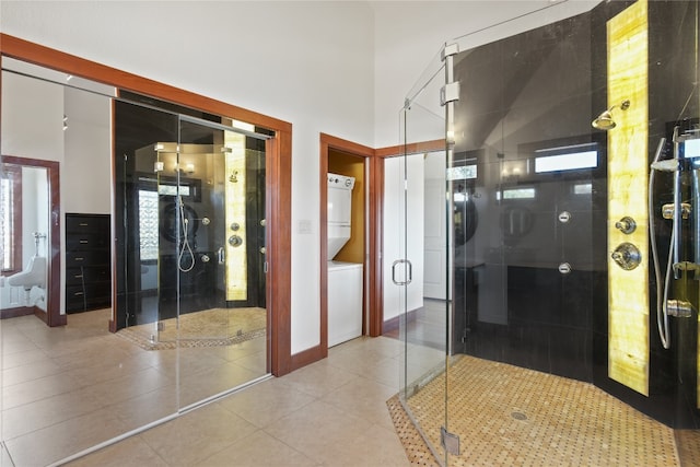 bathroom with tile patterned floors, stacked washer / dryer, and walk in shower