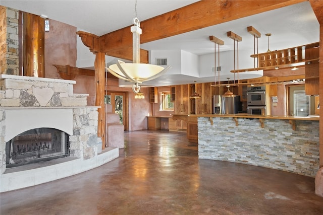 kitchen featuring a fireplace, stainless steel appliances, decorative light fixtures, and concrete flooring