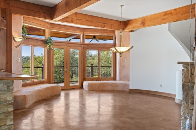 unfurnished living room with beam ceiling, french doors, and concrete flooring