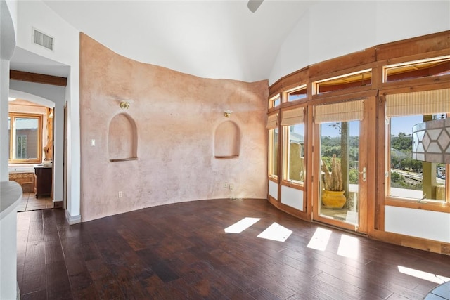 empty room with dark hardwood / wood-style flooring and high vaulted ceiling