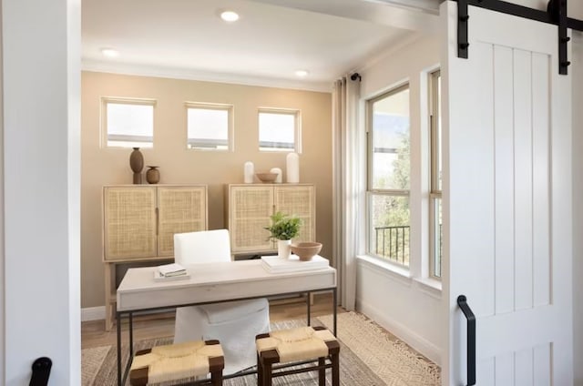 home office with wood-type flooring, a barn door, and a wealth of natural light