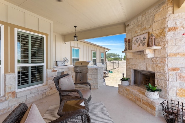 view of patio featuring fence, an outdoor stone fireplace, and area for grilling