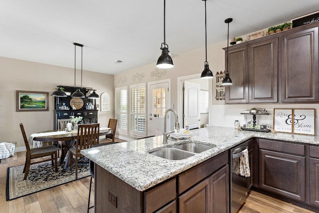 kitchen with dark brown cabinetry, dishwasher, a peninsula, light wood-style floors, and a sink