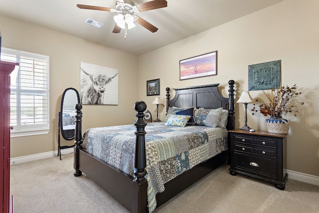 bedroom with light carpet, a ceiling fan, visible vents, and baseboards