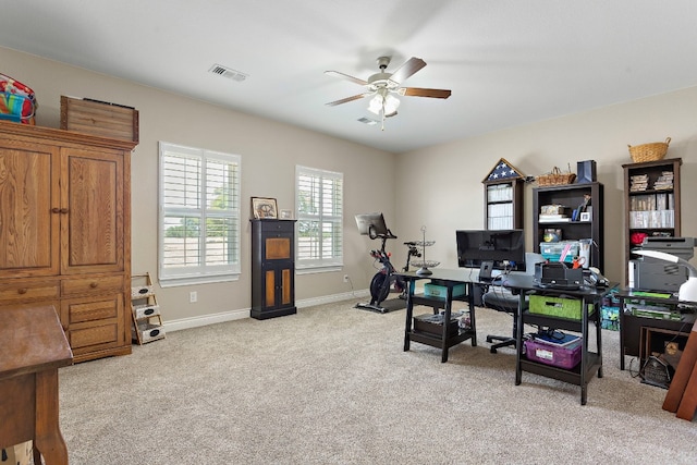 office space with light colored carpet, ceiling fan, visible vents, and baseboards