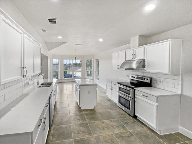 kitchen featuring a kitchen island, sink, range with two ovens, and white cabinets