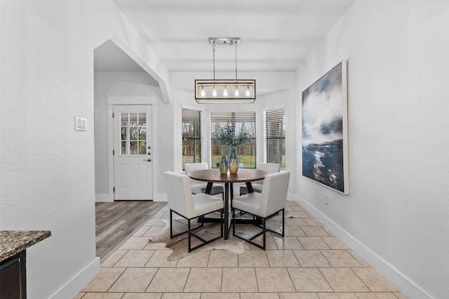 dining area with light hardwood / wood-style floors and an inviting chandelier