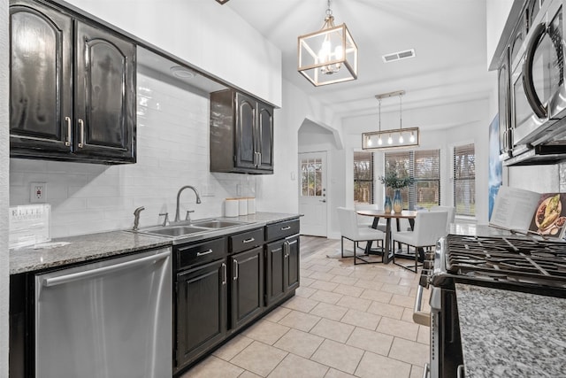 kitchen with decorative light fixtures, tasteful backsplash, sink, appliances with stainless steel finishes, and light tile patterned floors