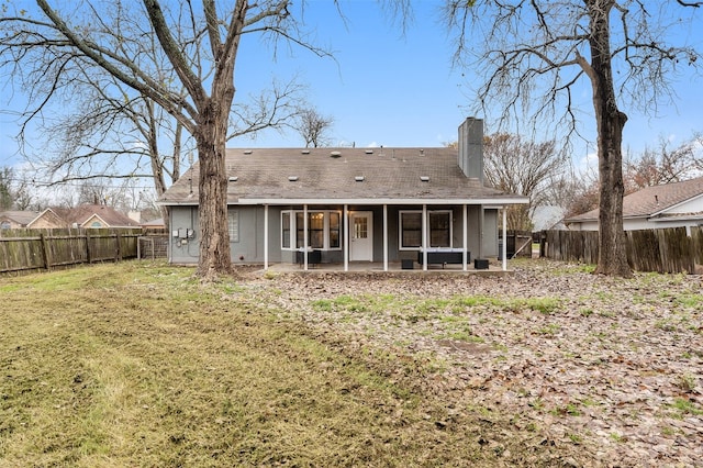 rear view of house featuring a lawn