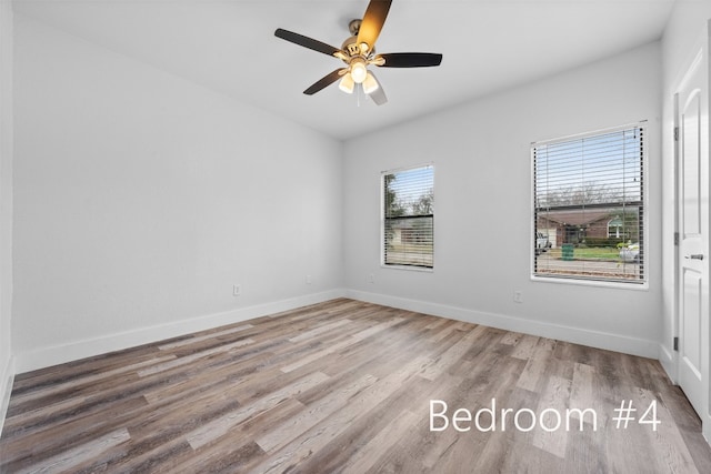 empty room with hardwood / wood-style floors and ceiling fan