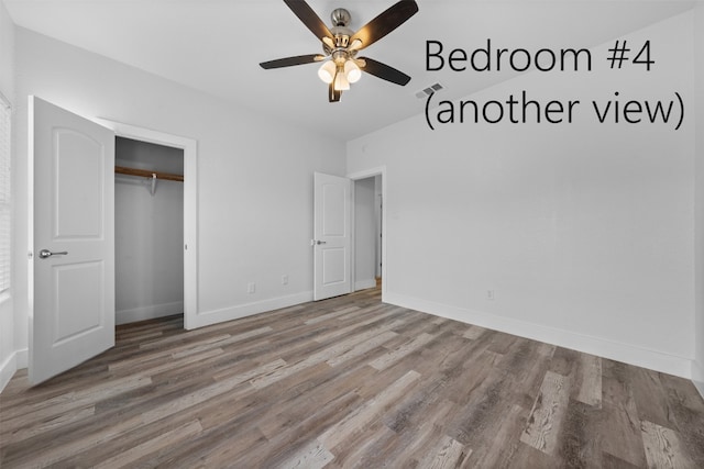 unfurnished bedroom with ceiling fan, hardwood / wood-style flooring, and a closet