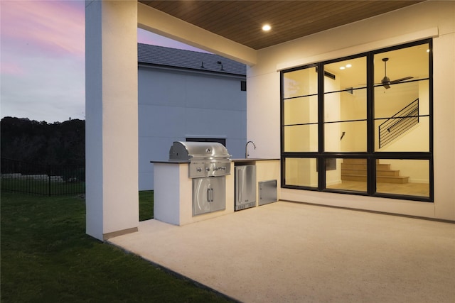 patio terrace at dusk with a grill and area for grilling