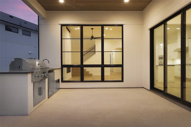 patio terrace at dusk with an outdoor kitchen and grilling area