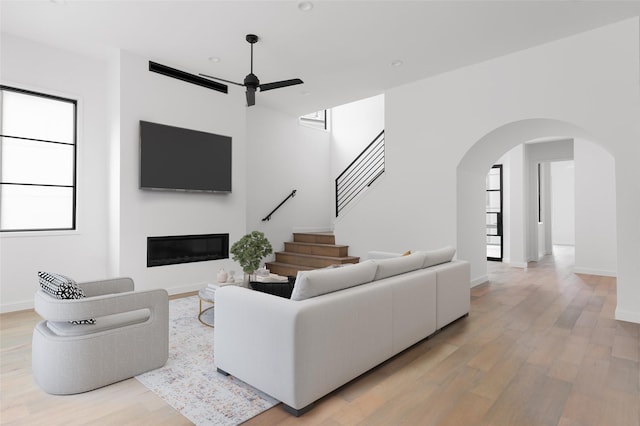 living room with ceiling fan and light hardwood / wood-style flooring