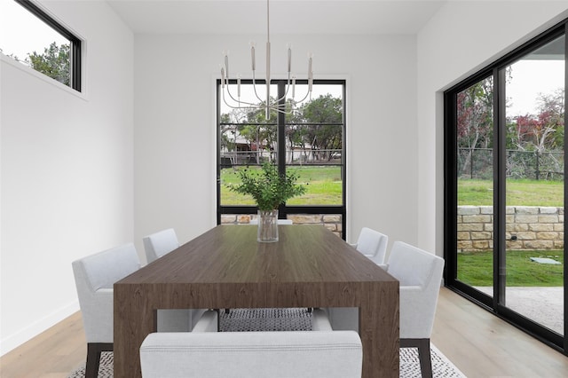 dining room featuring light wood-type flooring and a chandelier