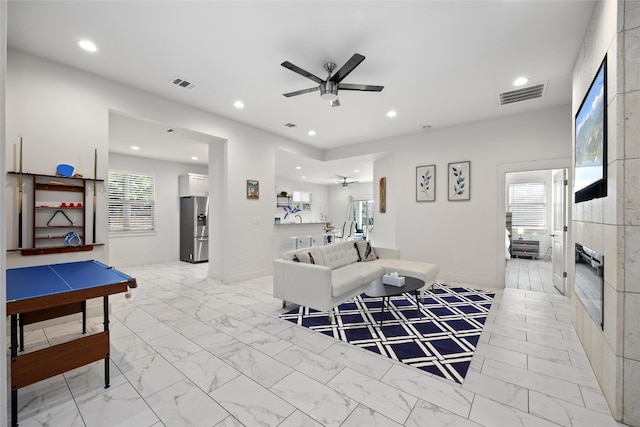 living room with ceiling fan and light tile patterned flooring