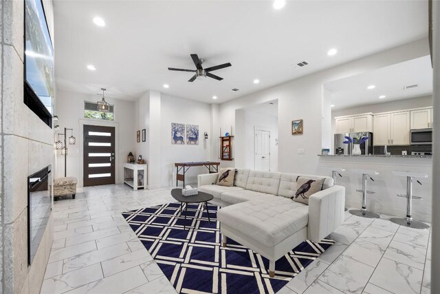 tiled living room with ceiling fan