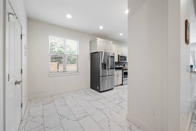 kitchen featuring white cabinets, appliances with stainless steel finishes, and light tile patterned floors