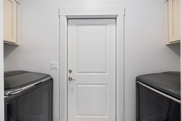 washroom featuring cabinets and washer and dryer