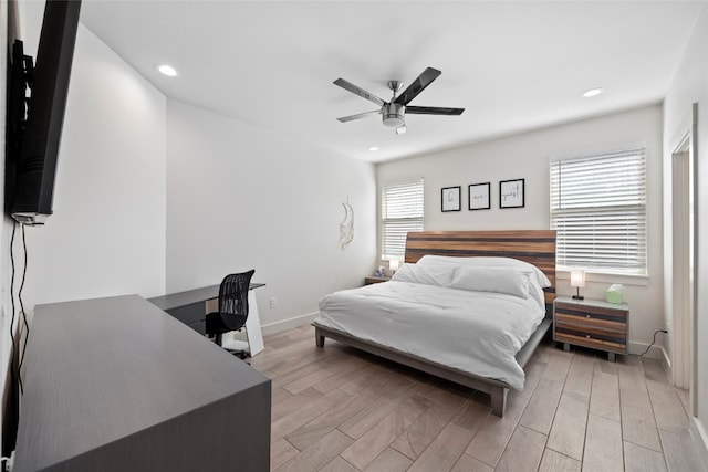 bedroom with ceiling fan, light wood-type flooring, and multiple windows