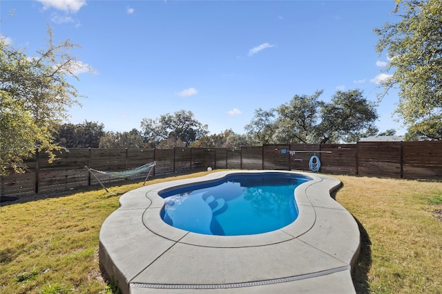 view of swimming pool with a yard