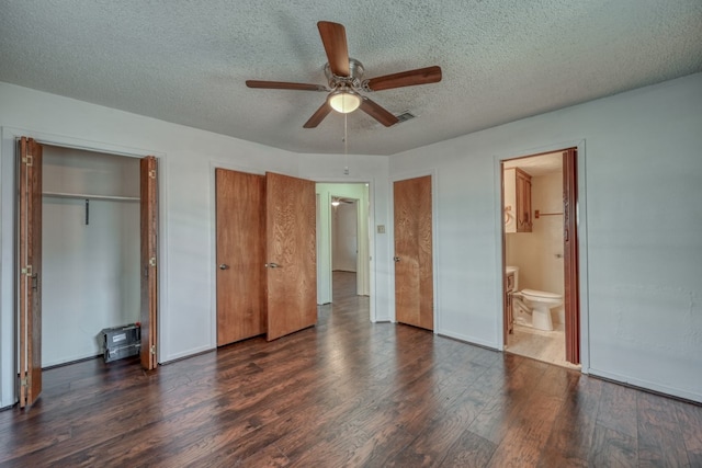 unfurnished bedroom featuring a textured ceiling, connected bathroom, ceiling fan, and dark wood-type flooring