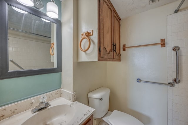 bathroom featuring vanity, toilet, and a textured ceiling