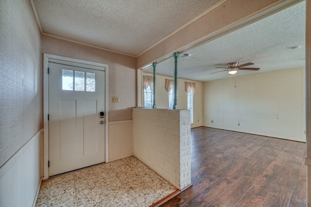 foyer entrance featuring ceiling fan, crown molding, a textured ceiling, and hardwood / wood-style flooring