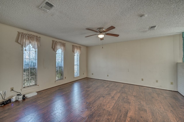 empty room featuring ceiling fan, dark wood-type flooring, and a textured ceiling