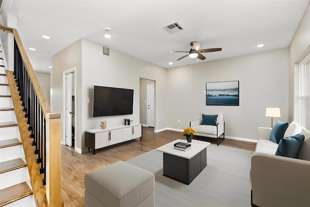 living room featuring wood-type flooring and ceiling fan