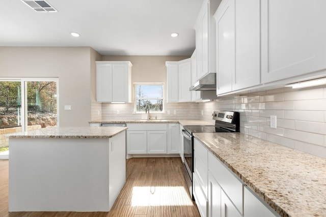 kitchen with electric stove, white cabinetry, sink, and light stone countertops