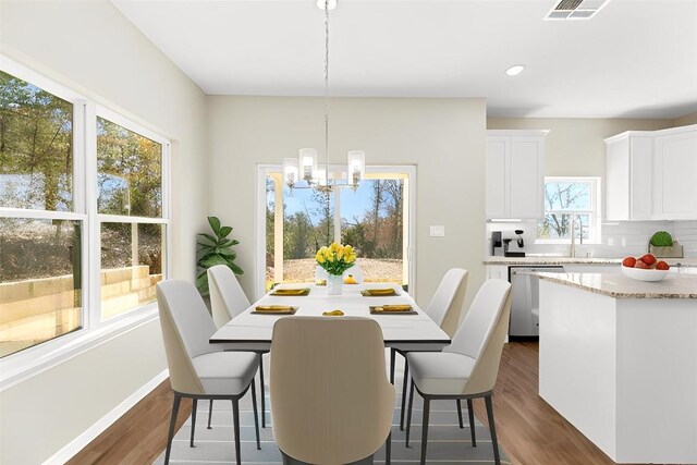 dining space with a notable chandelier, dark hardwood / wood-style floors, and sink