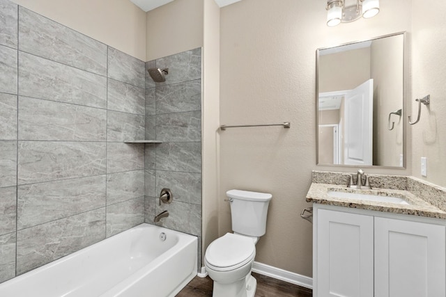 full bathroom with vanity, wood-type flooring, tiled shower / bath combo, and toilet