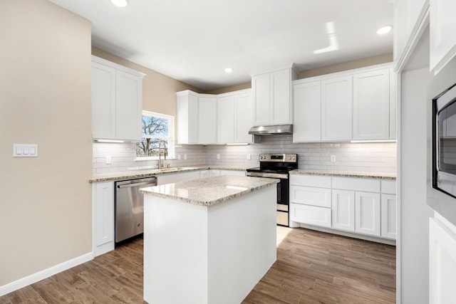 kitchen featuring white cabinets, a kitchen island, stainless steel appliances, and light hardwood / wood-style floors