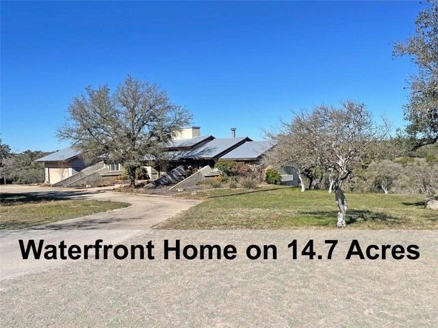 view of property hidden behind natural elements featuring a front lawn