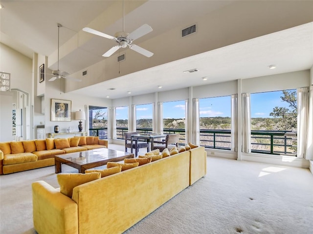 carpeted living room with high vaulted ceiling and ceiling fan