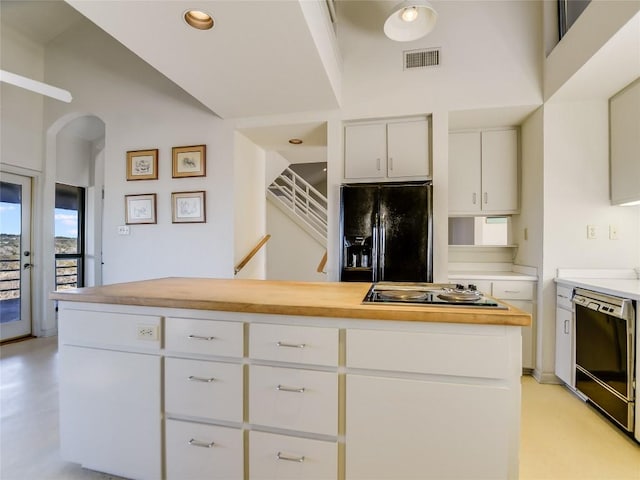 kitchen featuring white cabinets, black appliances, lofted ceiling, and wood counters