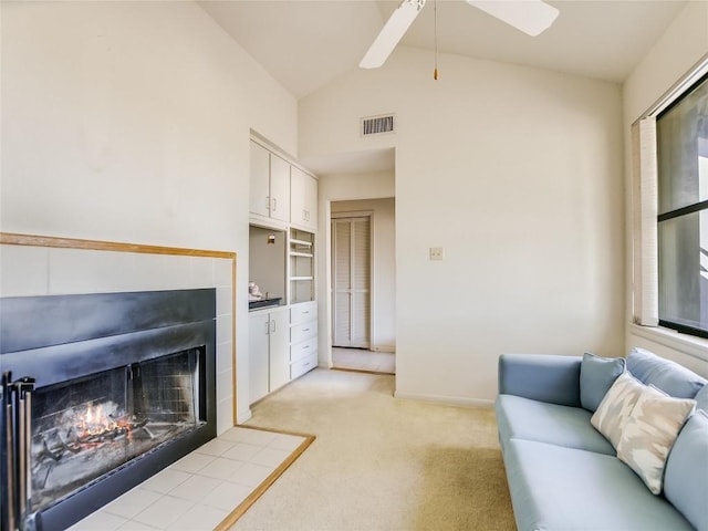 carpeted living room with a fireplace, vaulted ceiling, and ceiling fan