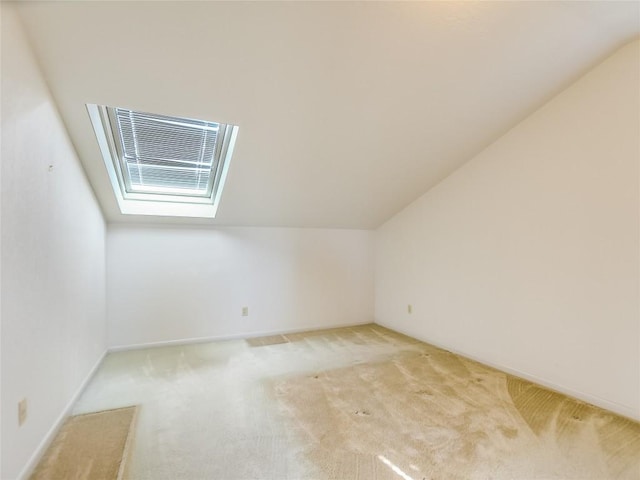 bonus room featuring light carpet and lofted ceiling with skylight